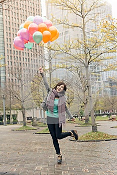 Happy smiling Asian woman holding balloons