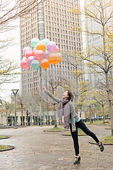 Happy smiling Asian woman holding balloons