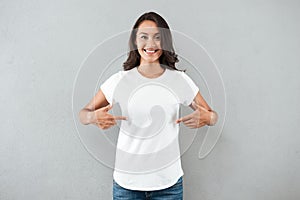 Happy smiling asian woman pointing with two fingers