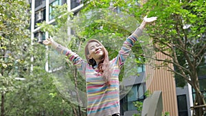 Happy smiling Asian woman Stand with arms outstretched and breathe fresh air in the outdoor garden