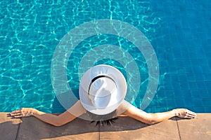 Happy smiling asian woman with straw hat relax and luxury in swimming pool at resort hotel, lifestyle and happy day