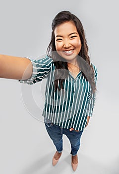 Happy smiling asian woman taking selfie