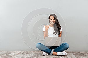 Happy smiling asian woman working on laptop computer