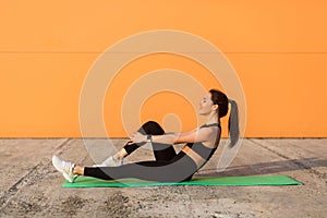 Happy smiling athletic girl in tight sportswear, black pants and top, doing aerobics gymnastics