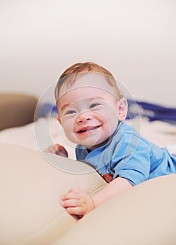 Happy smiling baby boy lie on a bed