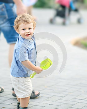 A happy smiling baby boy walking with young father at summer park. A family with a cute little son outside. Parental love, Father