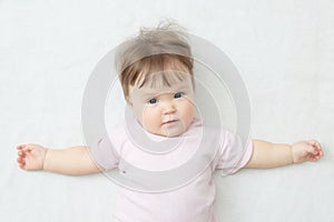 Happy smiling baby girl lying on white, portrait little, healthy child