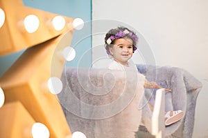 Happy smiling sweet baby girl sitting on armchair with shining light star, Birthday girl,  One year old