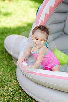 Happy smiling baby girl stay in swimming pool