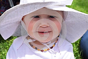 Happy smiling baby girl in white hat