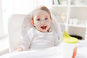 Happy smiling baby sitting in highchair at home