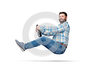 Happy smiling bearded man in plaid shirt rides a car holding steering wheel, looking at camera. Isolated on white background.