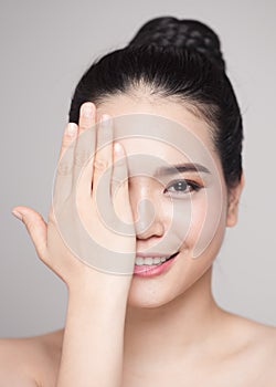 Happy smiling beautiful asian woman touching her face,  isolated on white background.