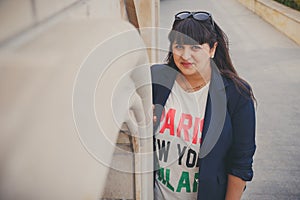 Happy smiling beautiful overweight young woman in dark blue jacket outdoors at the street. Confident fat young woman. Xxl woman, p