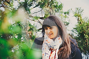 Happy smiling beautiful overweight young woman in dark blue jacket and scarf with anchor outdoors. Confident plus size woman.