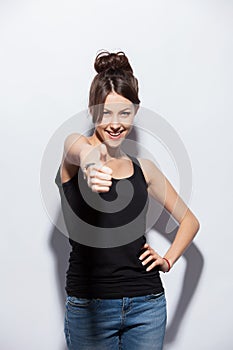 Happy smiling beautiful young brunette woman showing thumbs up gesture, isolated on white background.