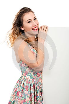 Happy smiling beautiful young woman showing blank signboard or c