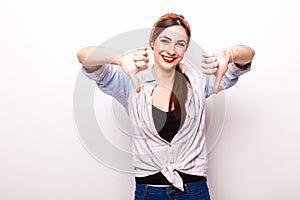 Happy smiling beautiful young woman showing thumbs down gesture photo