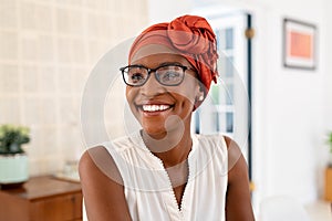 Happy smiling black woman with spectacles wearing african turban