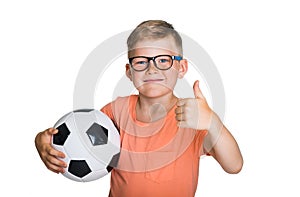 Happy smiling blond child boy in pink T-shirt with soccer ball showing thumb up isolated on white background. Winner kid