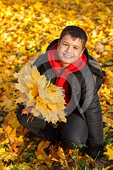 Happy smiling boy with autumn leaves