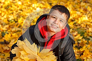 Happy smiling boy with autumn leaves