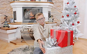 Happy smiling boy enjoying Christmas gift from his family