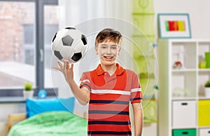 happy smiling boy holding soccer ball at home