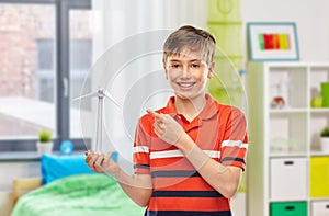 happy smiling boy holding toy wind turbine at home