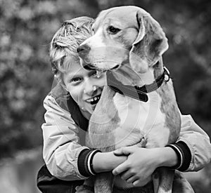 Happy smiling boy hugs his best freind beagle dog