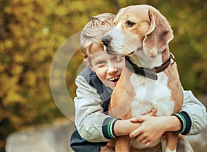 Happy smiling boy hugs his best friend beagle dog