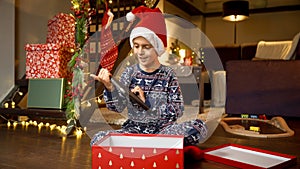 Happy smiling boy looking at his new tablet computer he got as present from Santa on Christmas