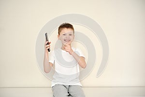 The happy smiling boy received a phone as a gift