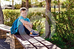 Happy smiling boy in sneakers and backpack