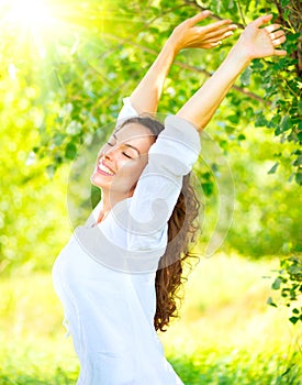 Happy and smiling brunette girl with healthy smile relaxing in the summer park