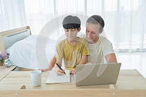 Happy smiling business blonde, man. Freelance working from home and his son, student teaching homework online with laptop computer