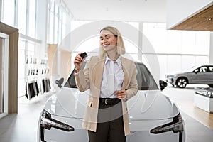 Happy smiling business lady standing near new bought car.