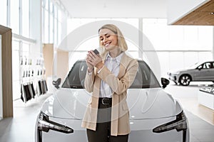 Happy smiling business lady standing near new bought car.