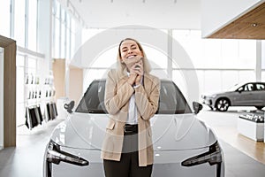 Happy smiling business lady standing near new bought car.