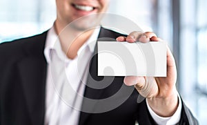 Happy smiling business man holding empty white business card