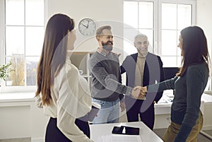 Happy, smiling business people meeting, making an acquaintance and shaking hands