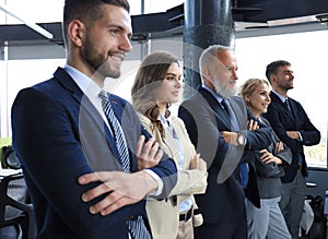 Happy smiling business team standing in a row at office