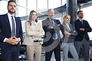 Happy smiling business team standing in a row at office