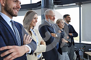 Happy smiling business team standing in a row at office