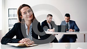 Happy smiling business woman sitting in office with her business team