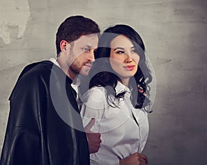 Happy smiling business woman and thinking businessman in white shirts on loft style wall studio background. Love and flirt in