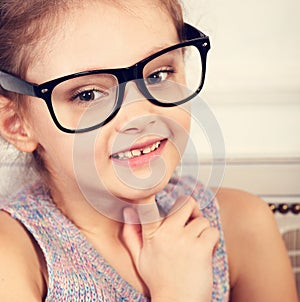 Happy smiling calm kid girl in eyeglasses looking. Closeup toned