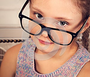 Happy smiling calm kid girl in eyeglasses looking. Closeup vintage toned portrait