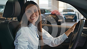 Happy smiling carefree cheerful Caucasian female driver inside car in automobile woman girl lady smile at camera
