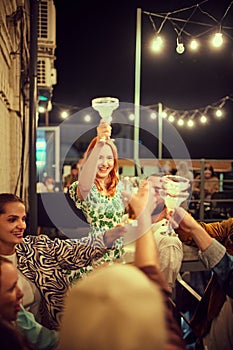 Happy, smiling, careless young people at outdoor party having fun, friends meeting, drinking and dancing